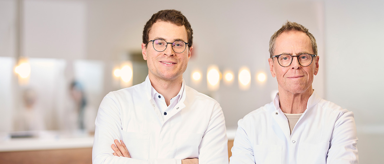 Dr. med. Anselm Baumann und Dr. med. Johannes Baumann vor dem Empfang in ihrer Lörracher Praxis